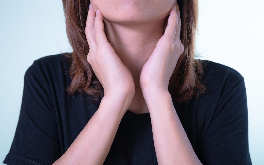 Woman gently holding her throat due to sore throat discomfort