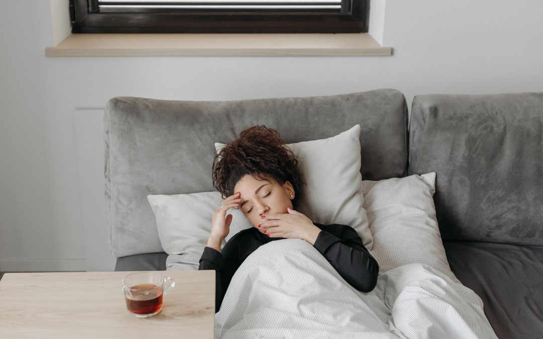 Woman resting on the sofa while recovering from the flu